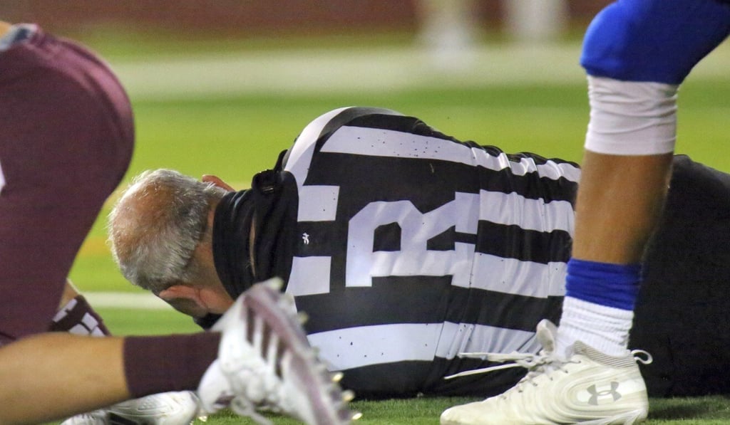 Football referee Fred Gracia lies on the ground rafter being charged by Edinburg's Emmanuel Duron in a high school zone play-in game in Edinburg, Texas. Photo: AP Football referee Fred Gracia lies on the ground rafter being charged by Edinburg's Emmanuel Duron in a high school zone play-in game in Edinburg, Texas. Photo: AP