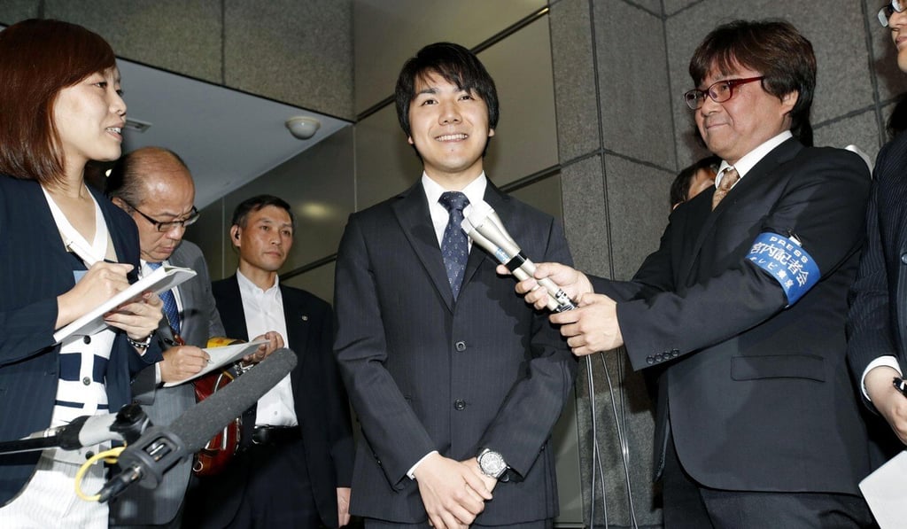Kei Komuro, centre, pictured in 2017 while being interviewed by reporters in Tokyo. Photo: Kyodo via AP Kei Komuro, centre, pictured in 2017 while being interviewed by reporters in Tokyo. Photo: Kyodo via AP