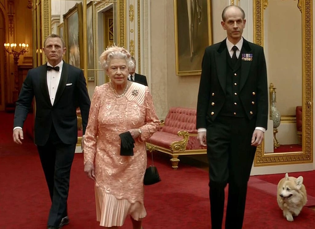 British actor Daniel Craig, playing James Bond, escorts Britain’s Queen Elizabeth through the corridors of Buckingham Palace. Photo: AFP Photo/LOCOG