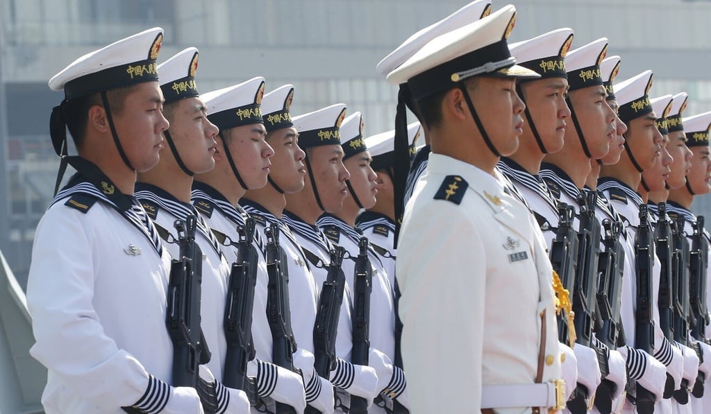 Chinese sailors stand in formation on the deck of a guided missile frigate as it docks in Manila for a four-day port call. Photo: AP