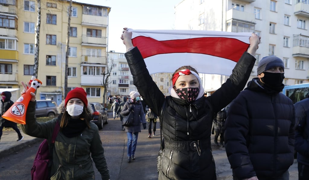 A demonstrator waves an old Belarusian national flag during an opposition rally in Minsk on Sunday. Photo: AP