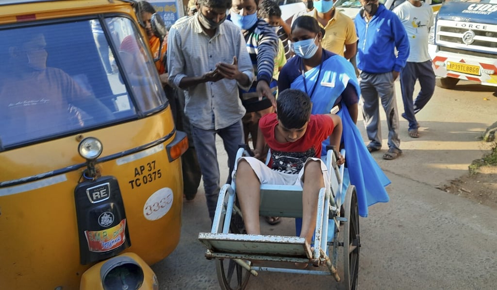 A young patient is brought in a wheelchair to the district government hospital in Eluru on Sunday. Photo: AP