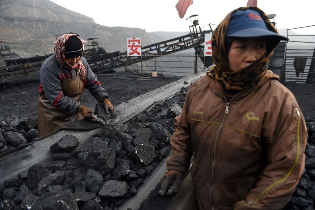 Workers sort coal on a conveyor belt near a coal mine in Datong, in China’s northern Shanxi province. Photo: AFP
