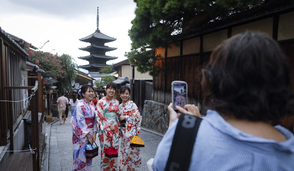 Kimono-clad women pose for a photo against the backdrop of Hokanji temple in Kyoto, a prime tourism destination. Photo: EPA-EFE