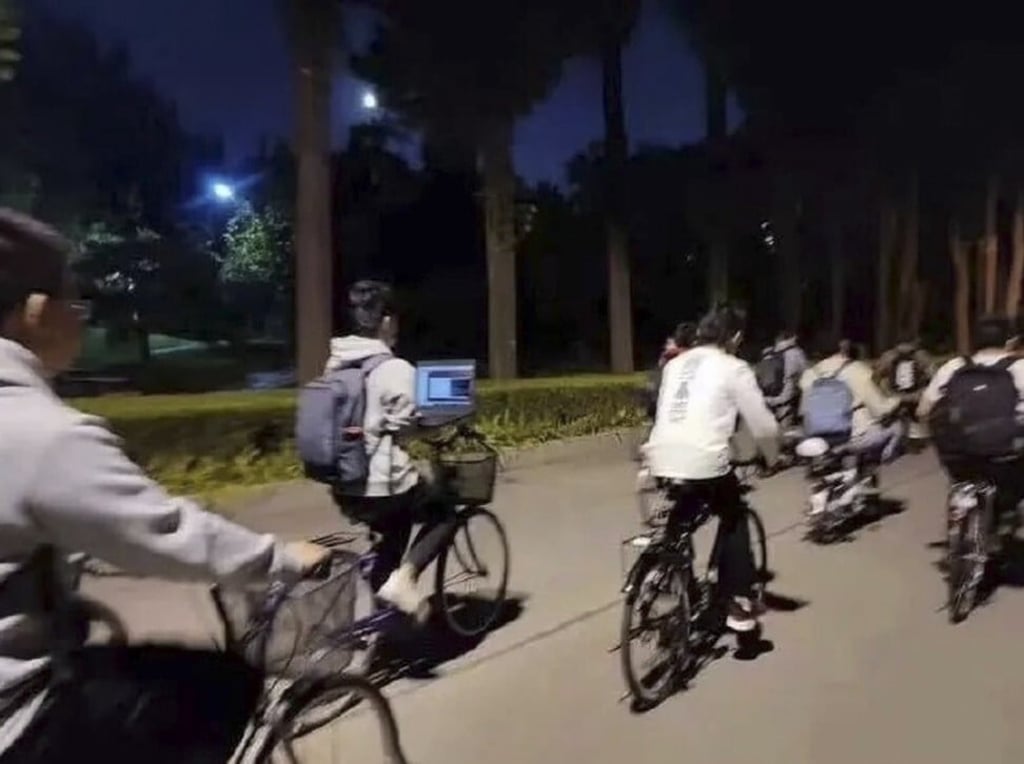 A video of a student holding a laptop running a program while riding a bicycle made the term “involution” viral in China. Photo: Bilibili