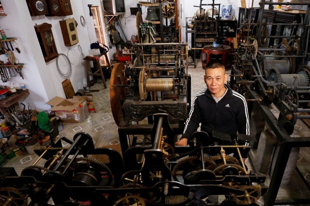 Pham Van Thuoc stands among old church clocks at his home in Thai Binh province. Photo: Reuters