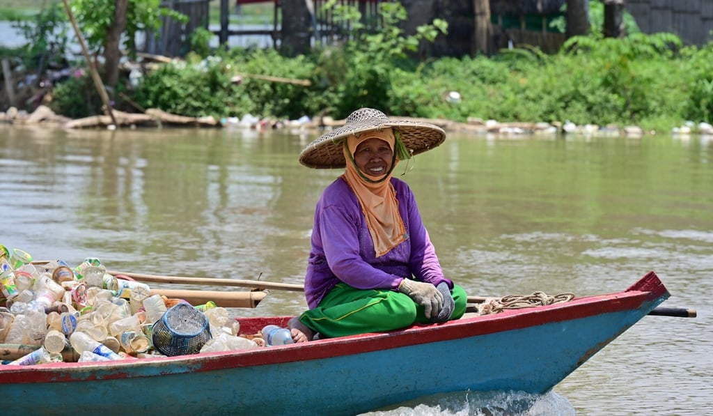 An Indonesian woman collecting recycled plastic cups on a boat near Teluk Naga, Tangerang, Banten province. Photo: AFP