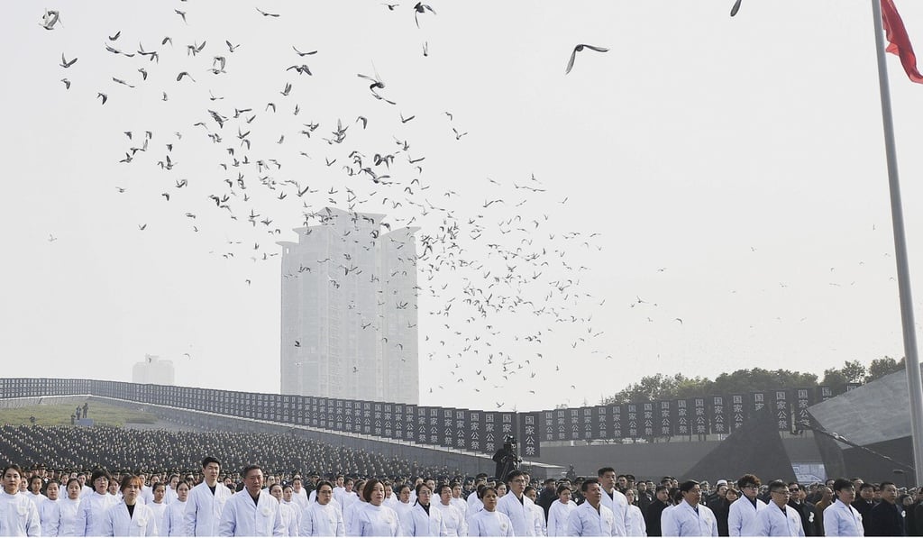 Pigeons fly over a crowd of people at the annual commemoration of the 1937 Nanking massacre in eastern China on Sunday. Photo: Xinhua