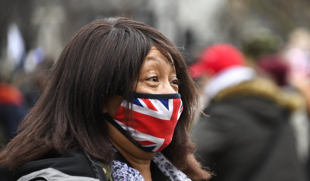 A woman wears a Union flag themed face mask as an anti-lockdown demonstration takes place in Parliament Square in London on Monday. Photo: AP A woman wears a Union flag themed face mask as an anti-lockdown demonstration takes place in Parliament Square in London on Monday. Photo: AP