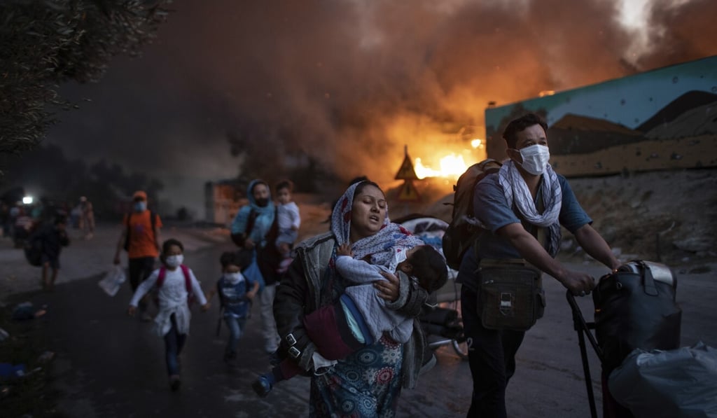 Migrants flee from the overcrowded Moria refugee camp on the island of Lesbos in September after it caught fire for the second time in two days. Photo: AP Migrants flee from the overcrowded Moria refugee camp on the island of Lesbos in September after it caught fire for the second time in two days. Photo: AP