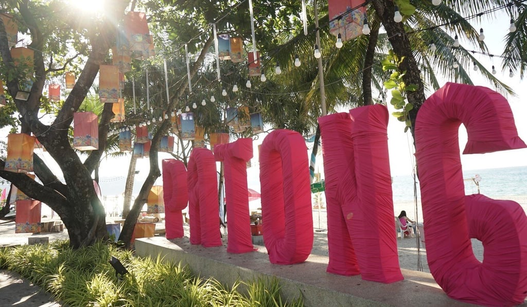 A sign for Patong on a beach with a few local tourists. Photo: Vijitra Duangdee