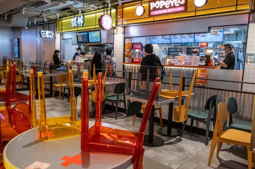 Chairs stacked on tables inside a closed fast food restaurant eating area in Hong Kong. Photo: Roy Liu/Bloomberg