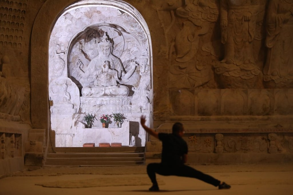 A visitor practices tai chi at the Hezhang Cliff Buddhist Grotto in Shunchang County, Nanping, Fujian province. Photo: Simon Song