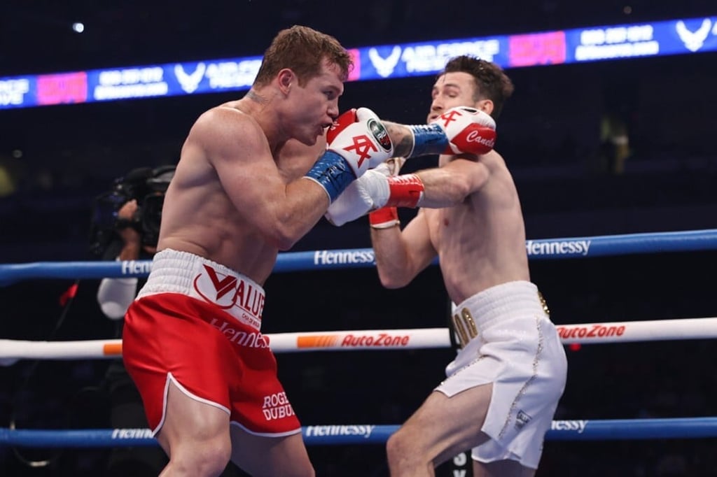 Saul Alvarez (red trunks) lands a left hand on Callum Smith during their WBA, WBC and Ring Magazine super middleweight championship bout. Photo: USA Today