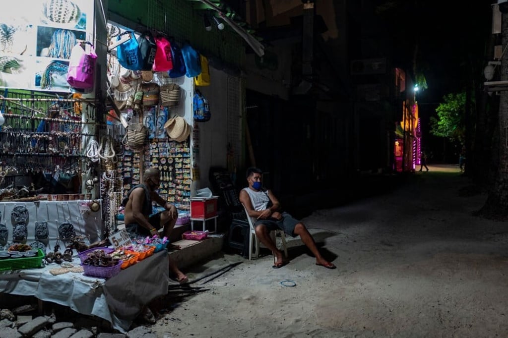 Staff sit outside an empty souvenir shop next to other closed shops in Boracay in October. Photo: Getty Images Staff sit outside an empty souvenir shop next to other closed shops in Boracay in October. Photo: Getty Images