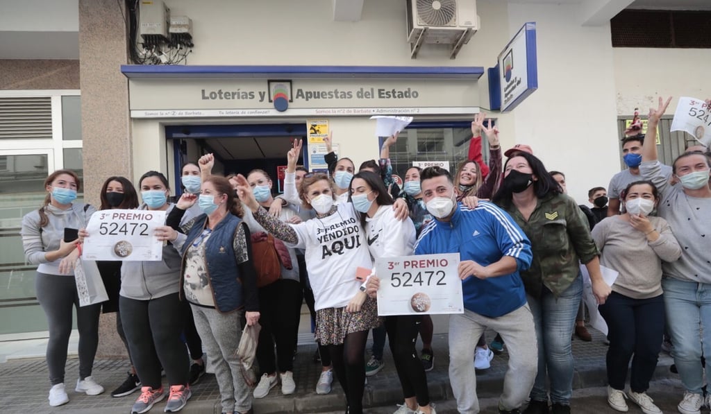 People celebrate they won the third prize (52472) at the traditional Christmas lottery draw in Barbate, Spain. Photo: EPA