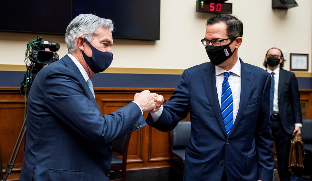 Federal Reserve chairman Jerome Powell and Treasury Secretary Steven Mnuchin bump fists after a House Financial Services Committee hearing in Washington on December 2. Fiscal and monetary stimulus has buoyed asset markets in 2020. Photo: Reuters
