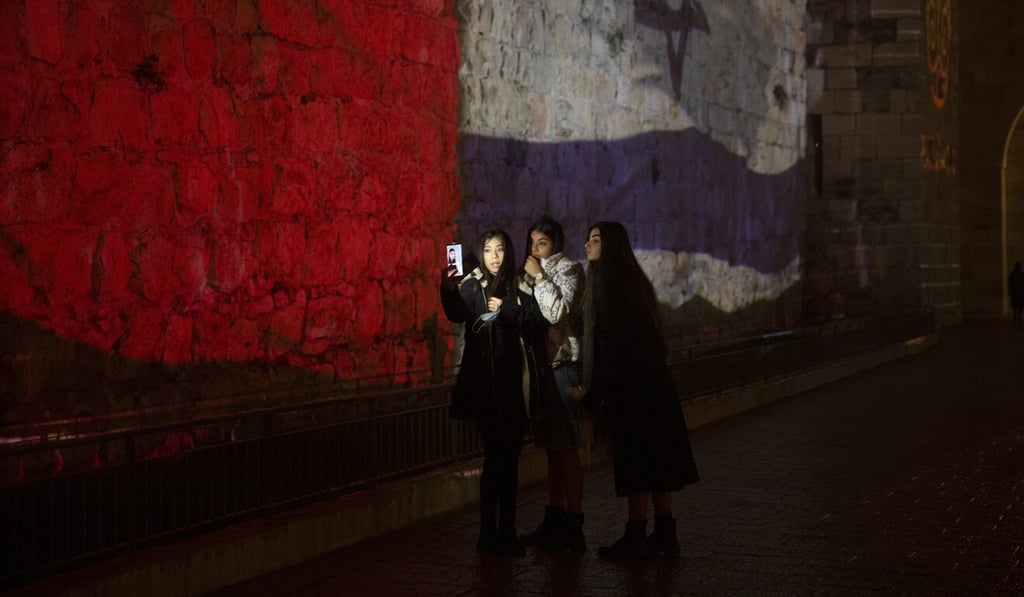 Three women pose for a selfie with projections of the national flags of Israel and Morocco on the walls of the Old City of Jerusalem on Wednesday. Photo: AP Three women pose for a selfie with projections of the national flags of Israel and Morocco on the walls of the Old City of Jerusalem on Wednesday. Photo: AP