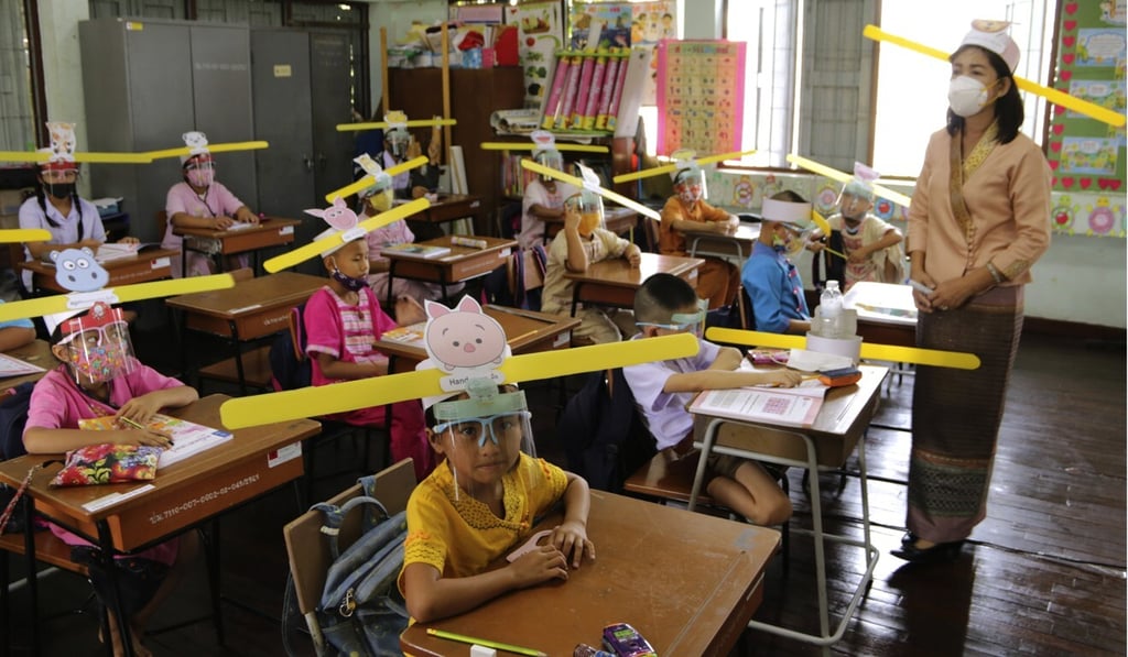 A teacher and students at a school in Chiang Mai, Thailand, wear hats designed to promote social distancing in July. photo: AP A teacher and students at a school in Chiang Mai, Thailand, wear hats designed to promote social distancing in July. photo: AP