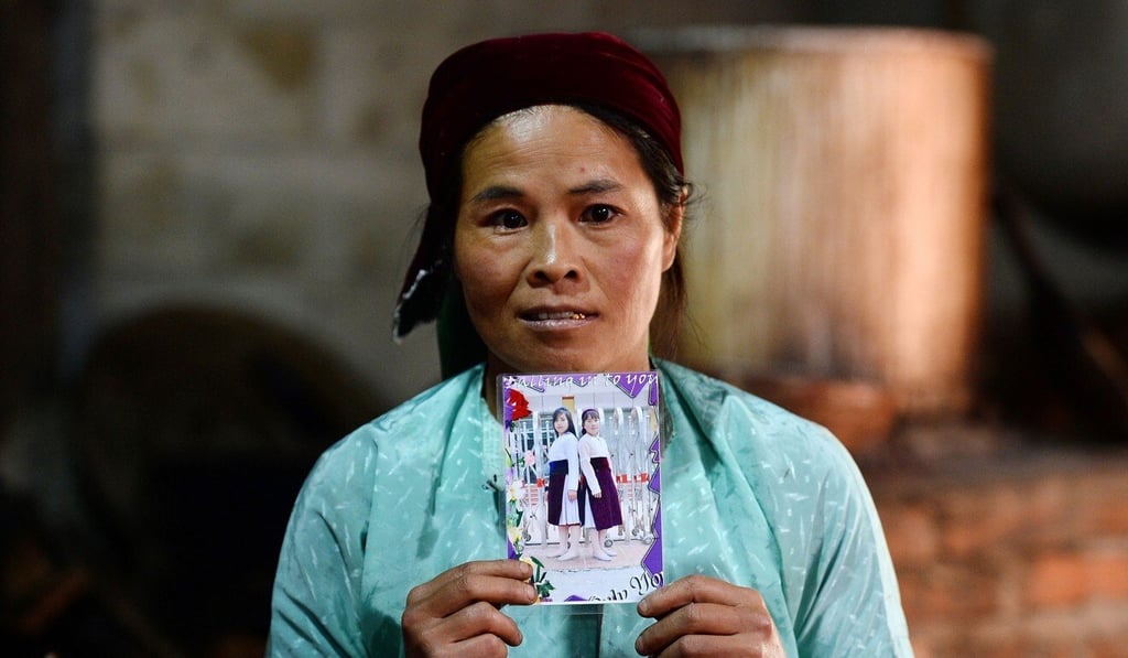 Ly Thi My, poses with a photograph of her missing daughter Di at her house in Meo Vac, a border district between Vietnam's Ha Giang province and China. Photo: AFP