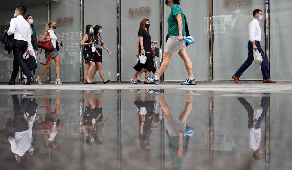Office workers wearing protective face masks walk in Singapore's central business district. Photo: Reuters