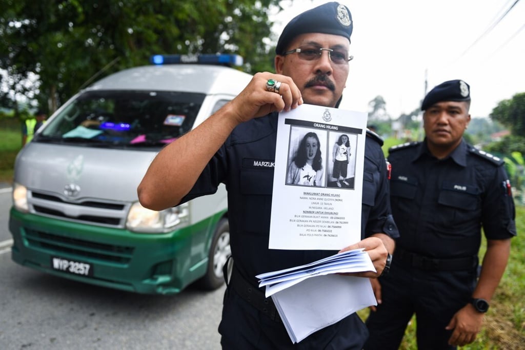 A Royal Malaysian Police officer holds a leaflet bearing a portrait of the missing teenager Nora Quoirin in August 2019. Photo: AFP