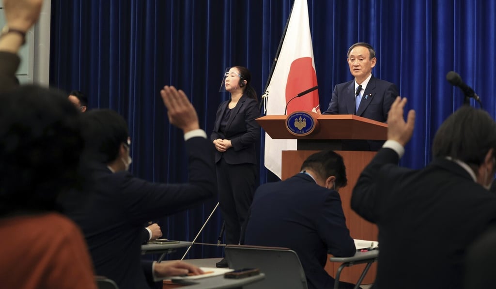 Journalists raise their hands as Japanese Prime Minister Yoshihide Suga gives a press conference at his official residence in Tokyo on Monday. Photo: AP Journalists raise their hands as Japanese Prime Minister Yoshihide Suga gives a press conference at his official residence in Tokyo on Monday. Photo: AP
