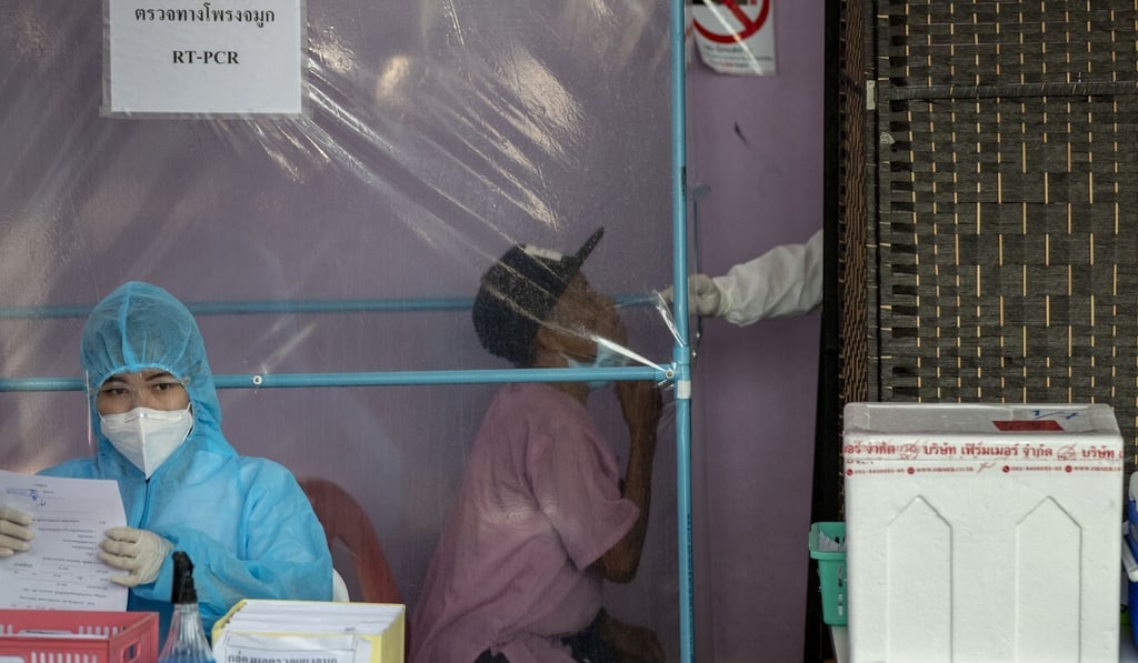 A migrant worker sits for a nasal swab at an outdoor Covid-19 testing centre in Samut Sakhon, south of Bangkok, on Monday. Photo: AP A migrant worker sits for a nasal swab at an outdoor Covid-19 testing centre in Samut Sakhon, south of Bangkok, on Monday. Photo: AP