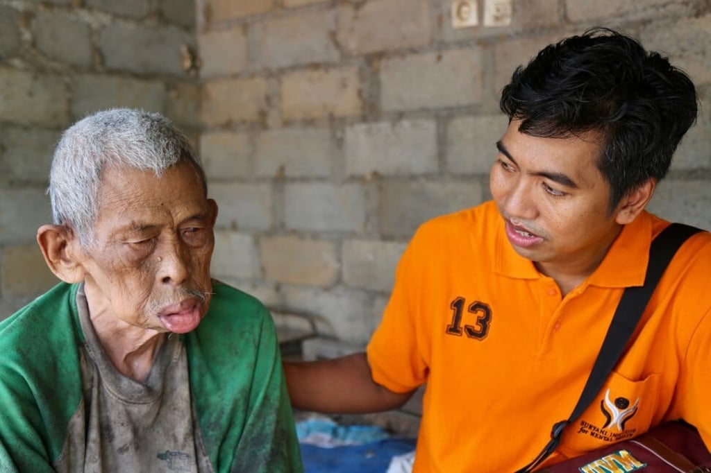 Dr Cokorda Bagus Jaya Lesmana comforts a man found living in abject poverty in east Bali. Photo: Dave Smith Dr Cokorda Bagus Jaya Lesmana comforts a man found living in abject poverty in east Bali. Photo: Dave Smith