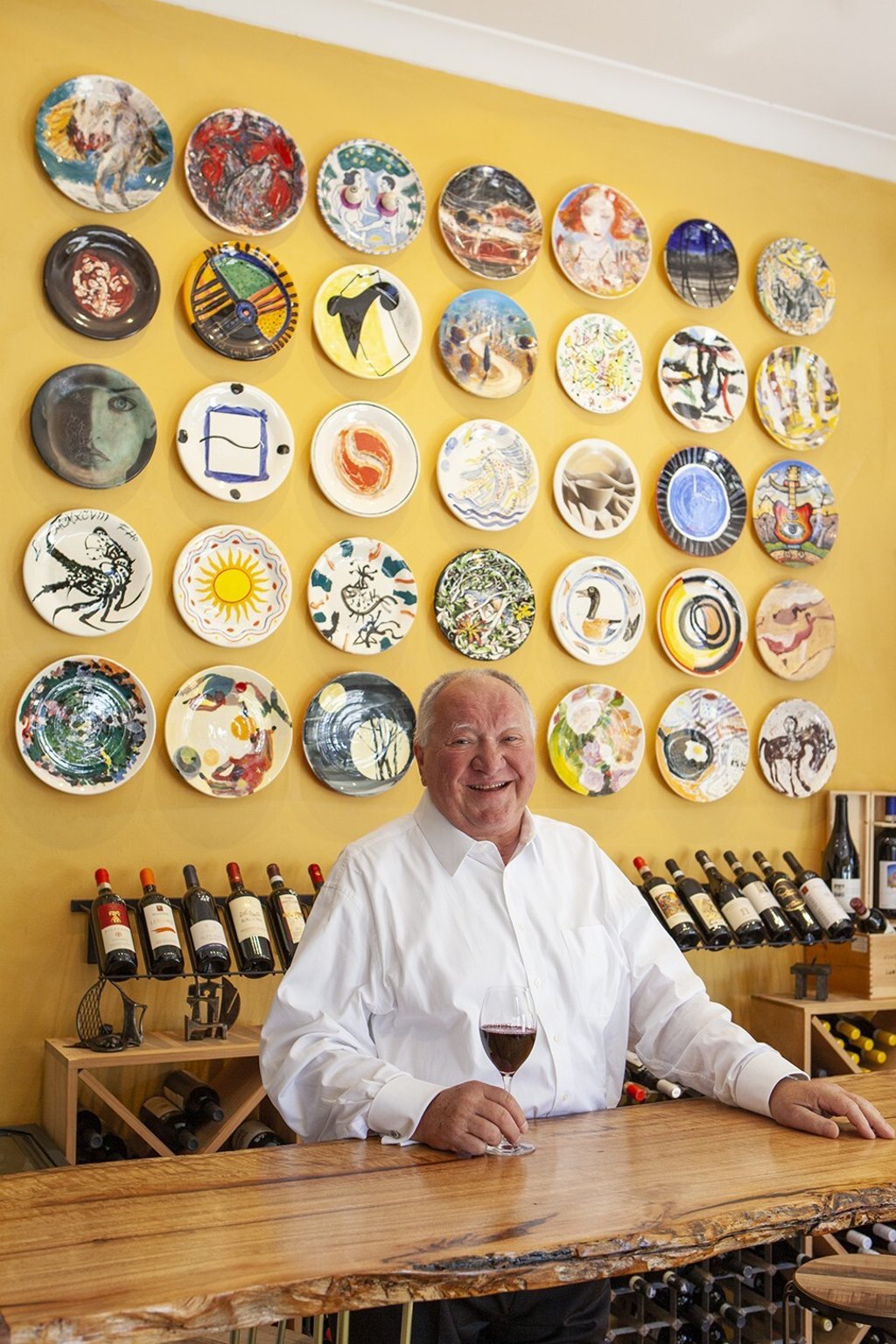 Lucio Galletto in front of a set of 35 plates that 35 Australian artists have painted for his restaurant. Photo: Courtesy of Lucio’s Lucio Galletto in front of a set of 35 plates that 35 Australian artists have painted for his restaurant. Photo: Courtesy of Lucio’s