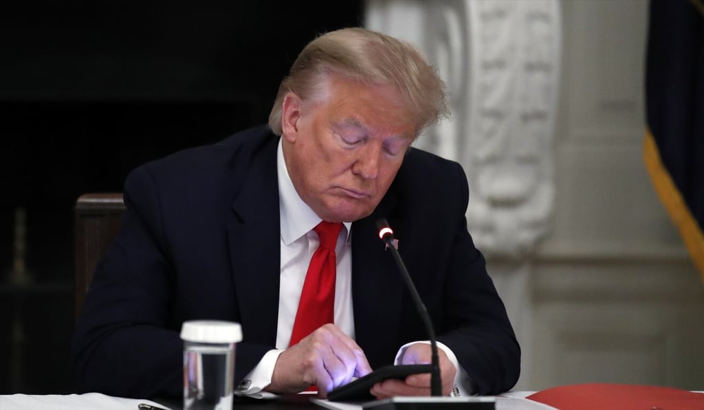 US President Donald Trump looks at his phone during a roundtable with governors on the reopening of America's small businesses at the White House in Washington. Photo: AP US President Donald Trump looks at his phone during a roundtable with governors on the reopening of America's small businesses at the White House in Washington. Photo: AP