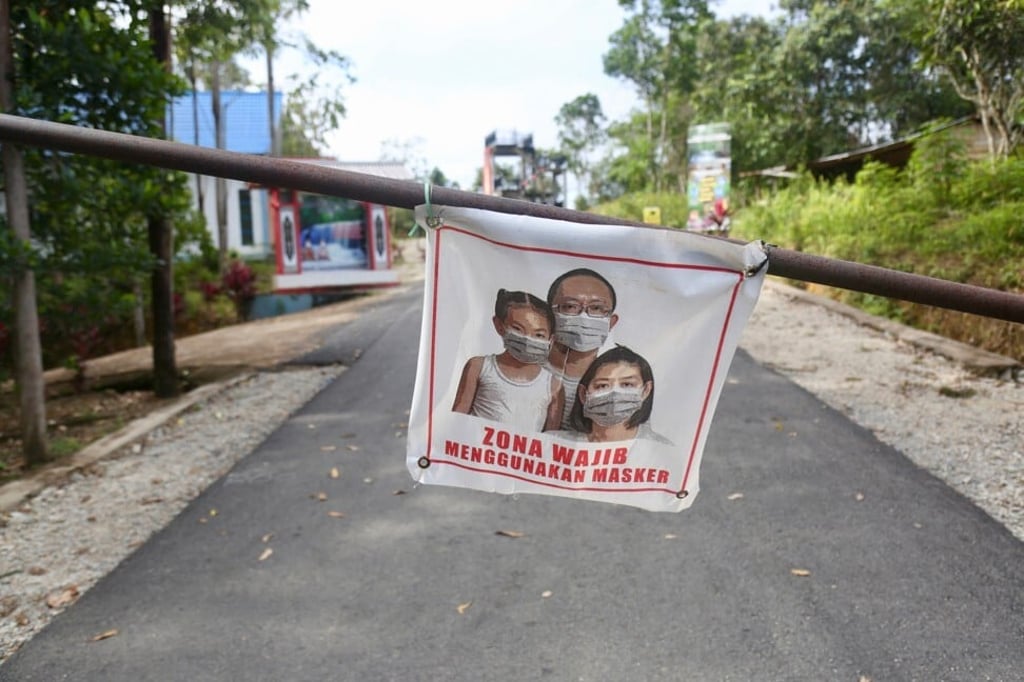 A poster encouraging visitors to wear face masks on the way to the Pancur Aji waterfall. Photo: Ian Neubauer A poster encouraging visitors to wear face masks on the way to the Pancur Aji waterfall. Photo: Ian Neubauer