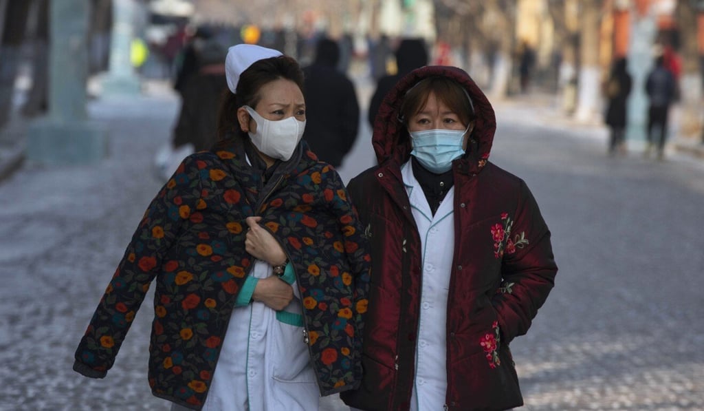 Health workers walk along a street in Harbin, the capital of Heilongjiang province. Photo: EPA-EFE