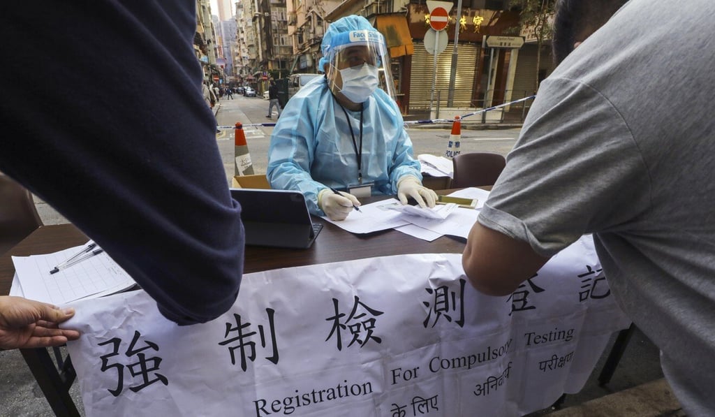 A medical worker in protective gear registers Yau Tsim Mong residents for mandatory Covid-19 testing on Monday. Photo: Dickson Lee