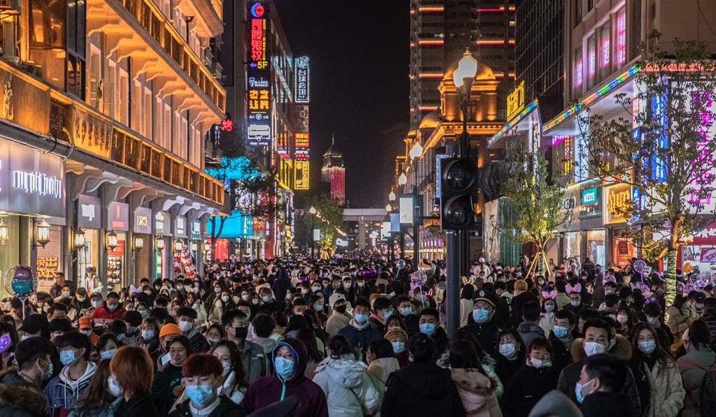 People with and without protective masks on their faces gather in a street on New Year's Eve in Wuhan, China, as life in the former epicentre of the coronavirus outbreak returns to normal. Photo: EPA-EFE