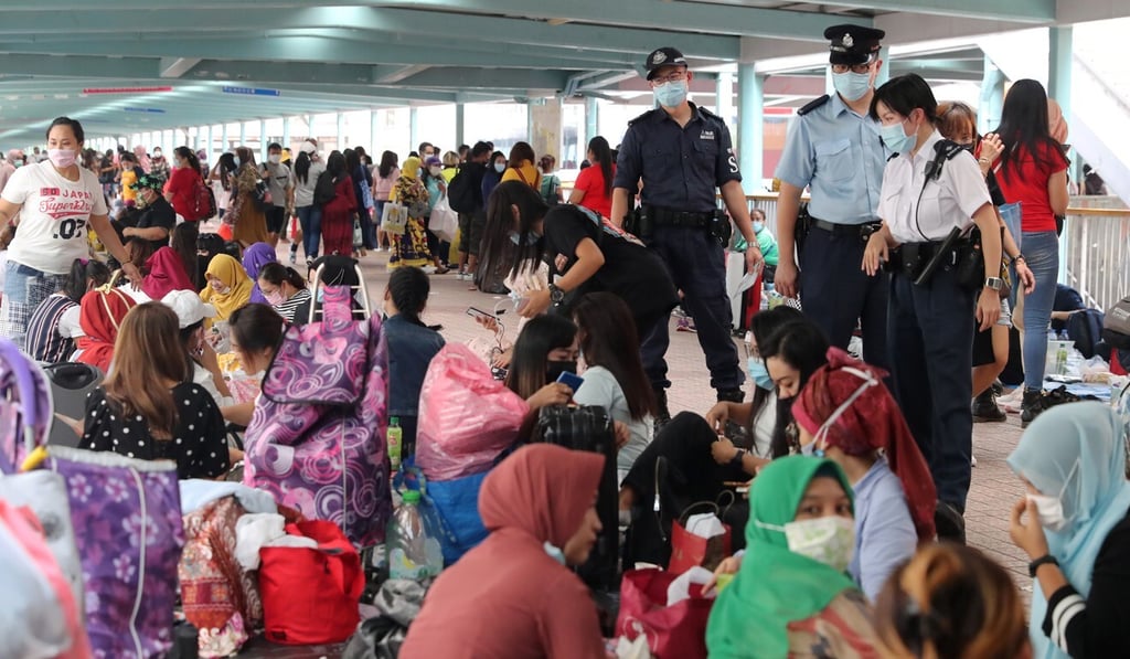 Police officers remind domestic helpers of social-distancing rules on a footbridge in Mong Kok. Photo: Edmond So Police officers remind domestic helpers of social-distancing rules on a footbridge in Mong Kok. Photo: Edmond So