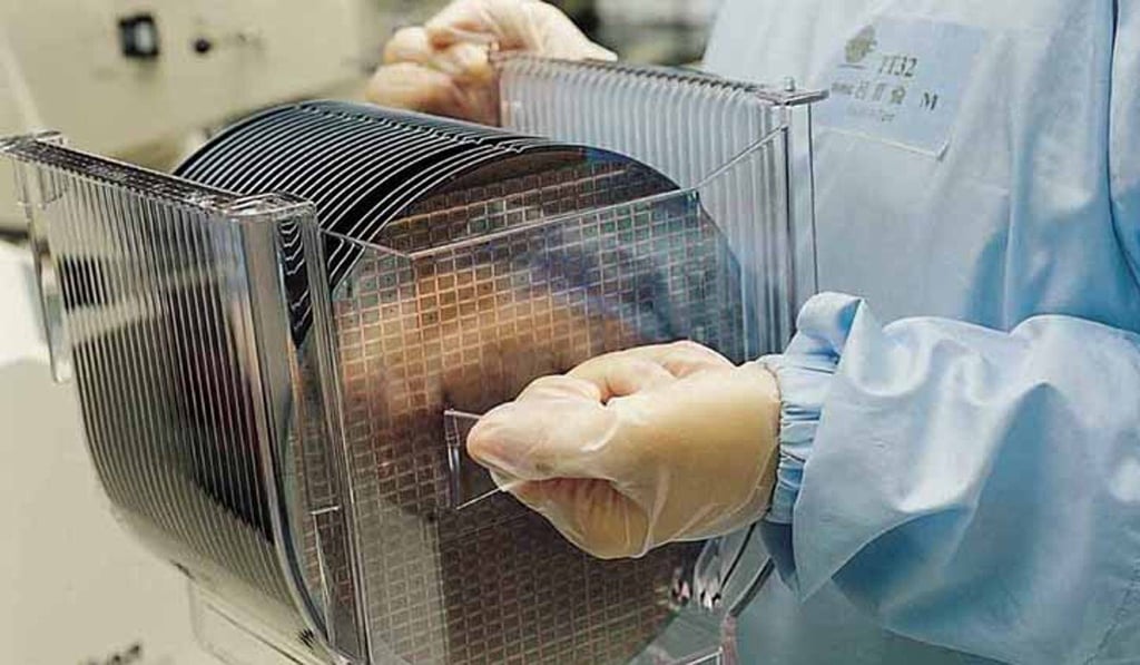 A worker at Taiwan Semiconductor Manufacturing Co, the world’s largest chip foundry, carries wafers used for the fabrication of integrated circuits. Photo: Handout A worker at Taiwan Semiconductor Manufacturing Co, the world’s largest chip foundry, carries wafers used for the fabrication of integrated circuits. Photo: Handout