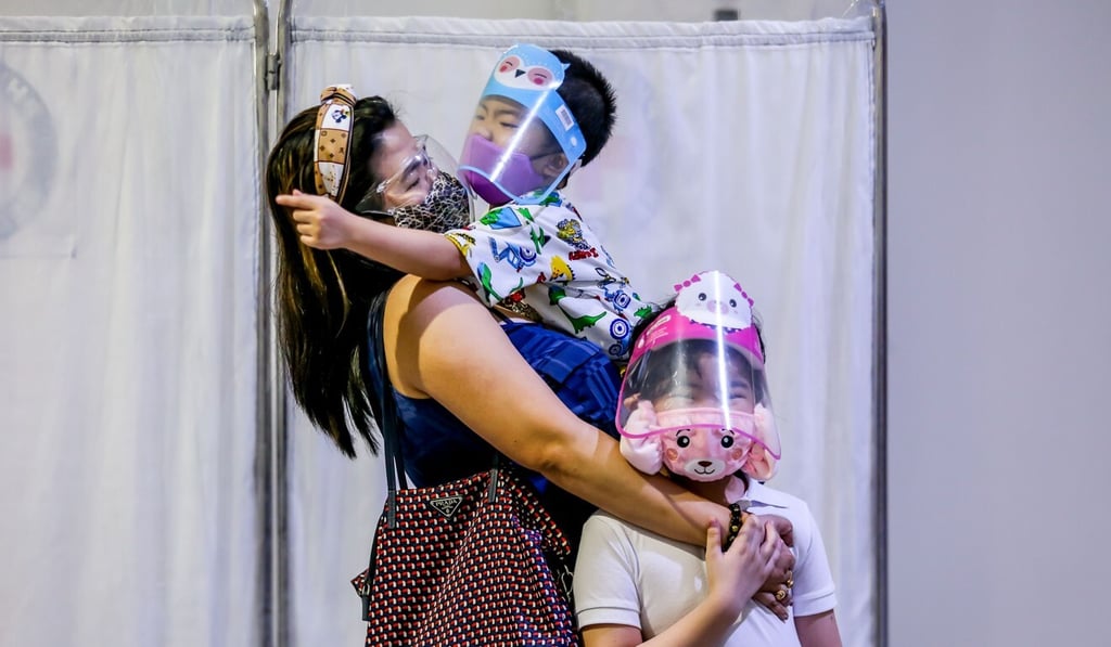 A mother and her children wait at a Covid-19 testing centre in Manila earlier this month. Photo: Xinhua