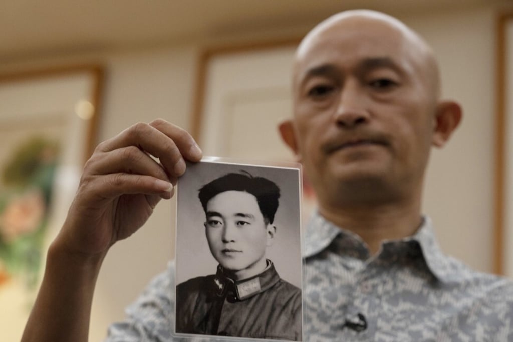 Zhang Hai holds up a photo of his father taken in his youth. Photo: AP Zhang Hai holds up a photo of his father taken in his youth. Photo: AP