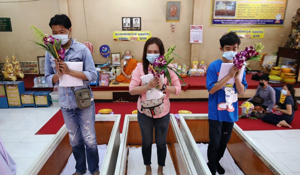 Devotees pray before lying down inside coffins at a temple in Bangkok on Wednesday. Photo: Reuters Devotees pray before lying down inside coffins at a temple in Bangkok on Wednesday. Photo: Reuters