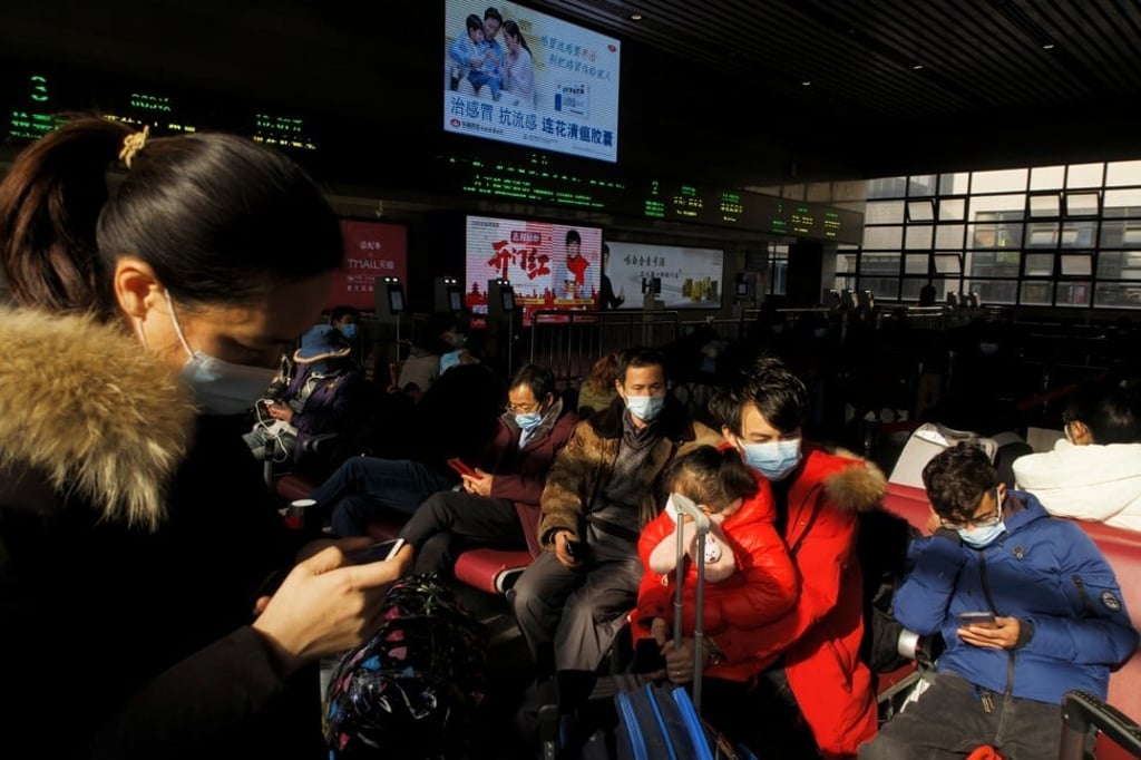 People check their smartphones as they wait for trains in the Beijing West railway station on Wednesday. Photo: Reuters