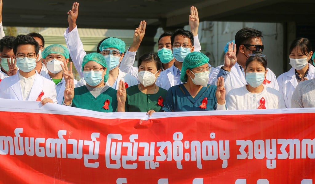 Medical staff in Myanmar wear red ribbons and raise the three-finger salute in protest against the military coup. Photo: DPA Medical staff in Myanmar wear red ribbons and raise the three-finger salute in protest against the military coup. Photo: DPA