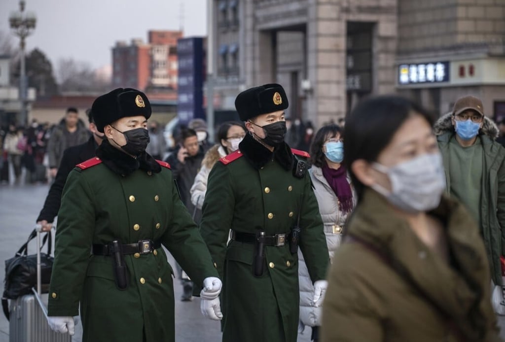 Chinese police officers patrol at Beijing Station before the annual Spring Festival. Officials and volunteers implement virus control members rigorously when an outbreak of coronavirus occurs. Photo: Getty Images