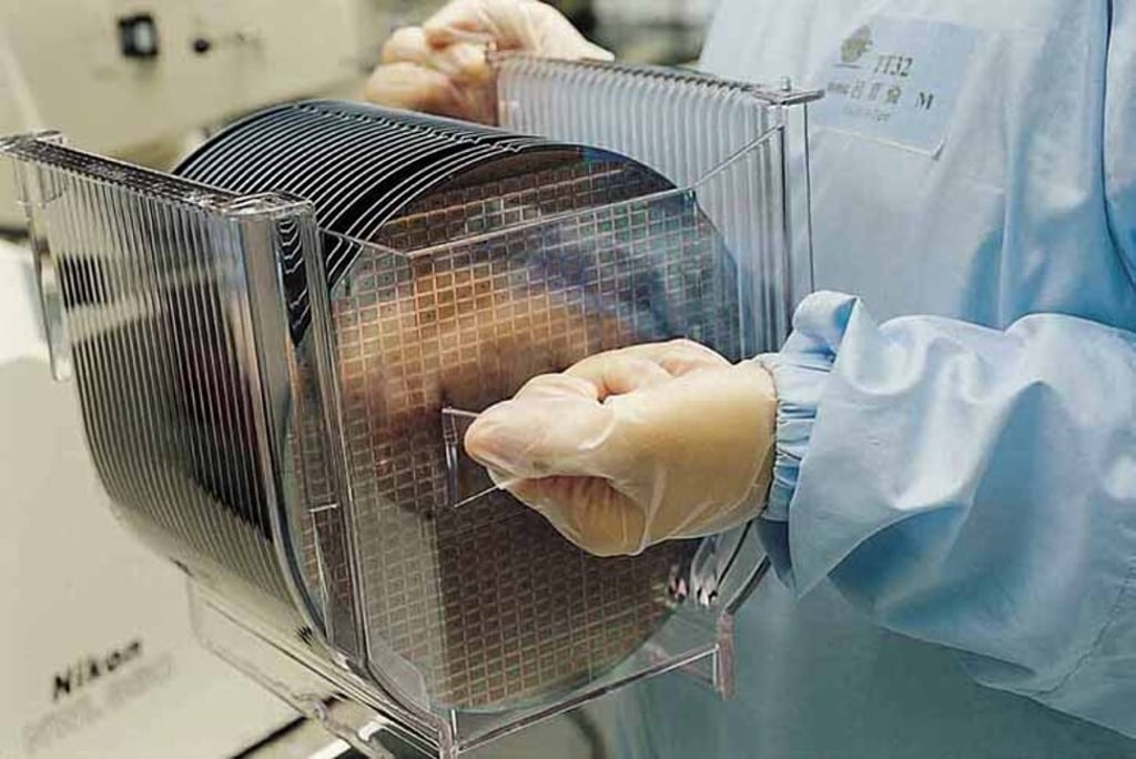 An employee of chip maker Taiwan Semiconductor Manufacturing Co carries a batch of 8-inch silicon wafers at one of its fabrication plants in the island. Photo: Handout
