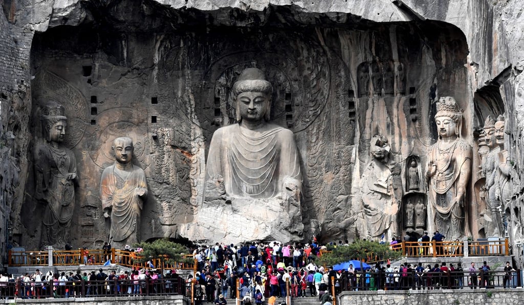 People visit the Longmen Grottoes in Luoyang, in central China’s Henan province, on April 11, 2018. The grottoes feature stone carvings from the late Northern Wei and Tang dynasties. Photo: Xinhua
