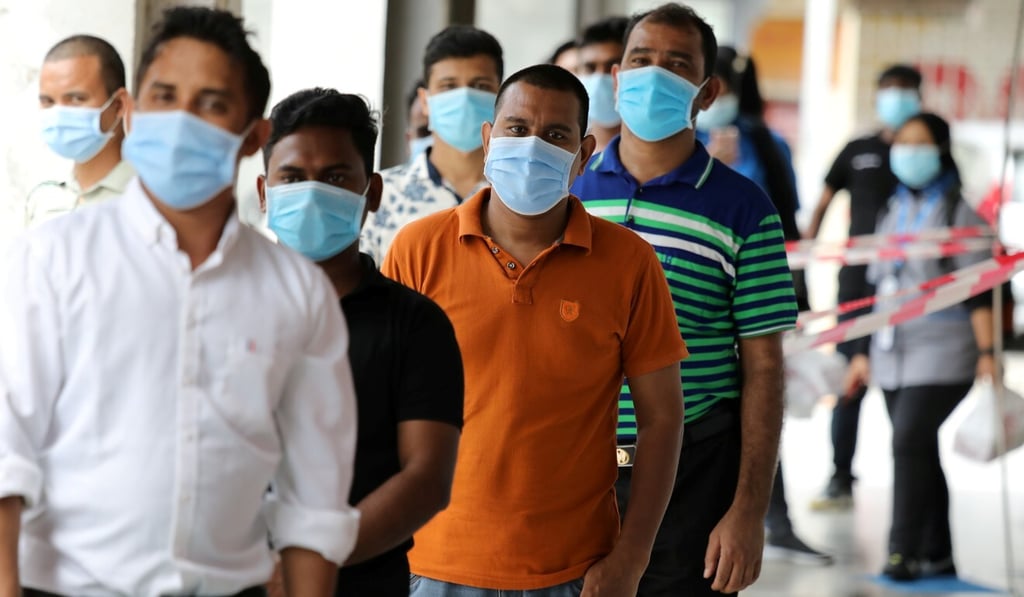 Foreign workers wait in line to be tested for Covid-19 outside a clinic in Kajang, Malaysia. Photo: Reuters Foreign workers wait in line to be tested for Covid-19 outside a clinic in Kajang, Malaysia. Photo: Reuters