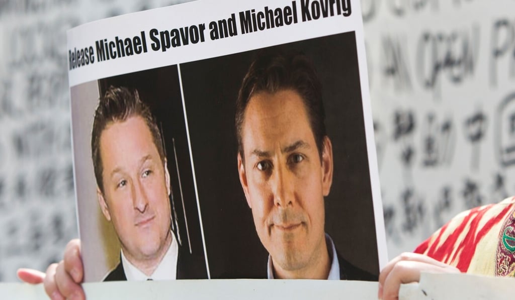 Turnisa Matsedik-Qira of the Vancouver Uygur Association demonstrates against China's treatment of Uygurs while holding a photo of detained Canadians Michael Spavor (left) and Michael Kovrig outside a Vancouver court appearance for Huawei Chief Financial Officer Meng Wanzhou in May 2019. Photo: AFP