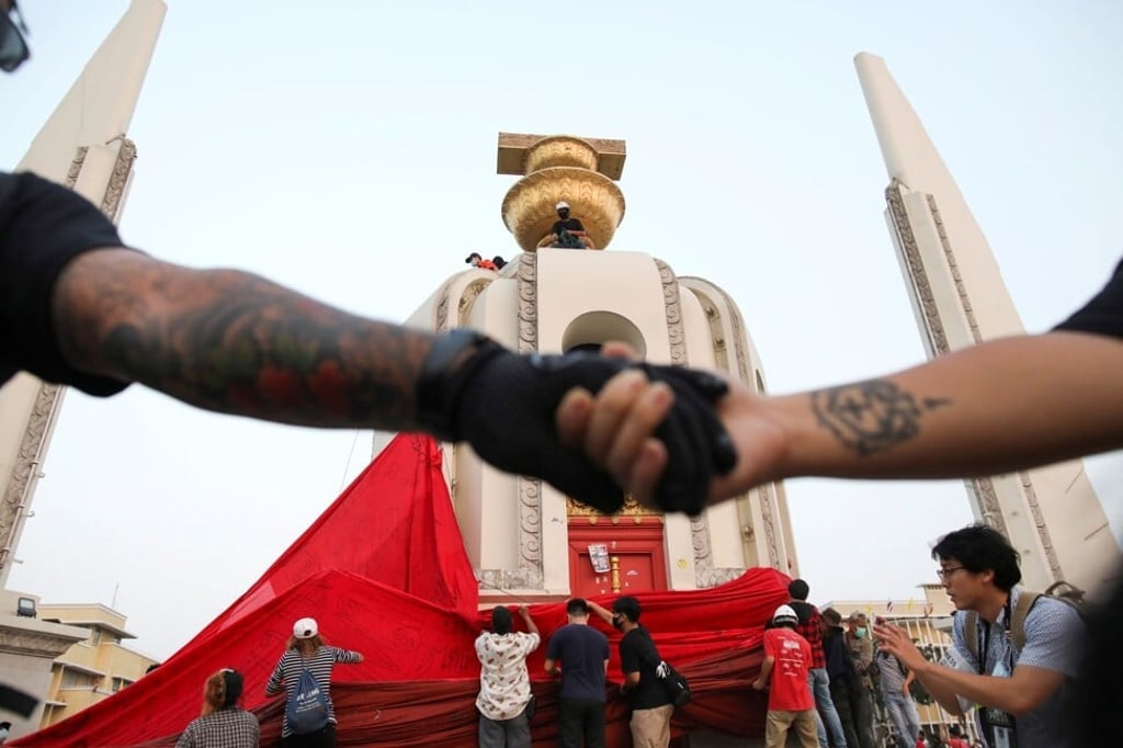 Anti-government protesters cover the Democracy Monument in Bangkok with a red cloth during a February 13 rally calling for the revocation of the kingdom’s royal defamation law. Photo: Reuters Anti-government protesters cover the Democracy Monument in Bangkok with a red cloth during a February 13 rally calling for the revocation of the kingdom’s royal defamation law. Photo: Reuters