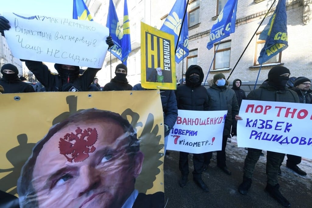 Members and supporters of right-wing parties hold placards, including one depicting Viktor Medvedchuk, during a rally in Kiev, Ukraine, on Friday. Photo: AFP