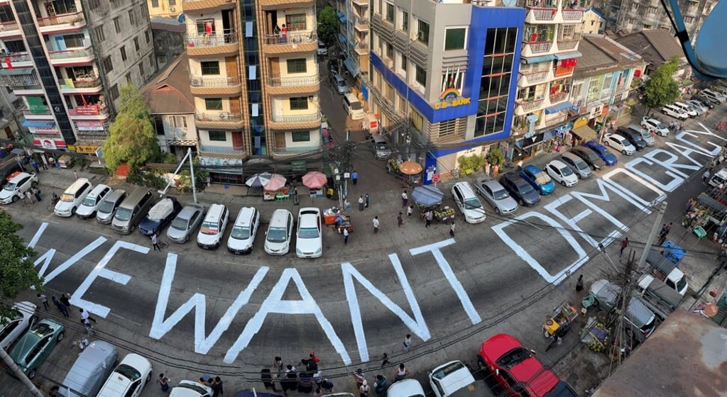 Protesters write a pro-democracy on a Yangon street on February 21. Photo: Reuters